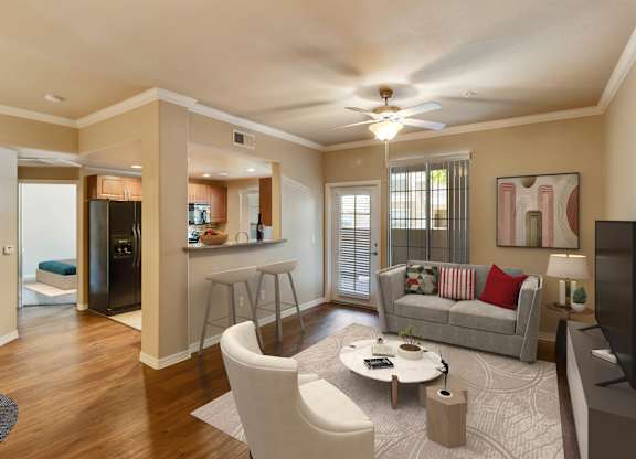 A living room with a grey couch, a coffee table, and a television. at Superstition Canyon Apartments, Apartments, Mesa, AZ