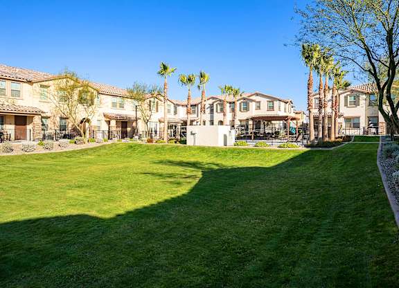 A large grassy area in front of a row of houses.