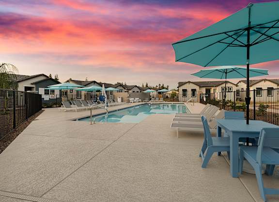 a swimming pool with blue tables and chairs and umbrellas at Villas on Ash, Arizona