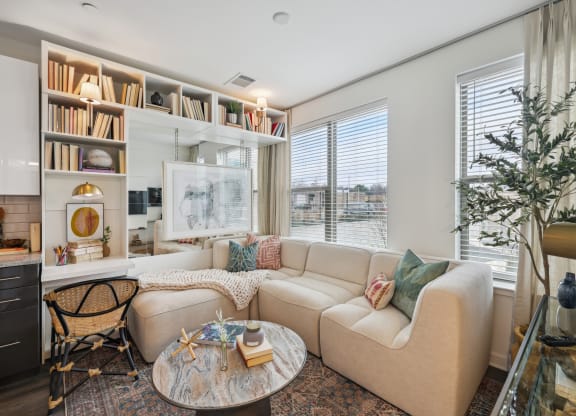 a living room with a couch and a table     and a window at Link Apartments® Broad Ave, Memphis
