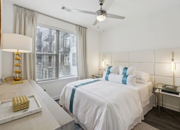 a white bedroom with a large bed and a ceiling fan at Link Apartments® Broad Ave, Memphis, 38112