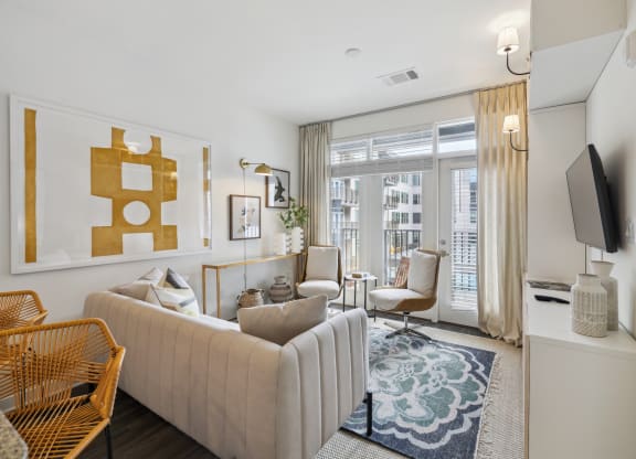 a living room with a white couch and a large window at Link Apartments® Broad Ave, Memphis