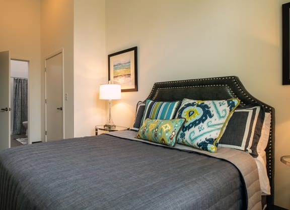 a bedroom with a bed and a door to a bathroom at Link Apartments® Canvas, Atlanta, GA, 30312