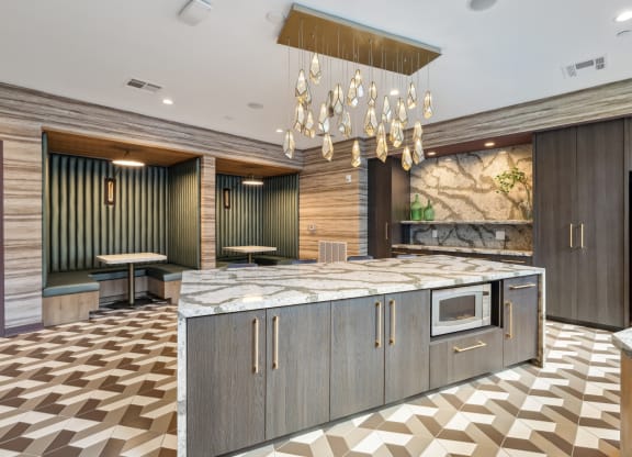 a large kitchen with marble countertops and a chandelier at Link Apartments® Broad Ave, Memphis, TN