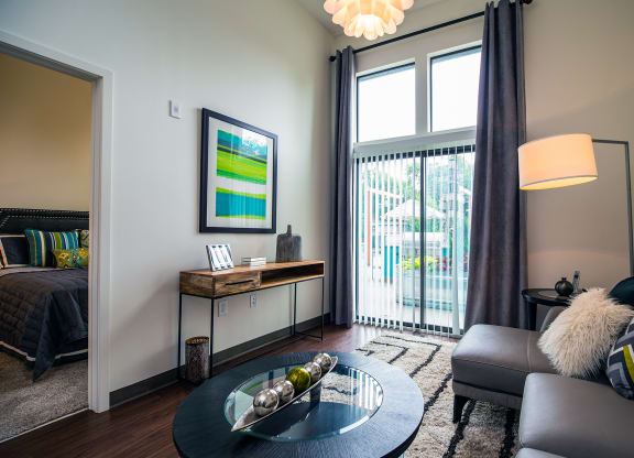 a living room with a large window and a sliding glass door at Link Apartments® Canvas, Georgia, 30312
