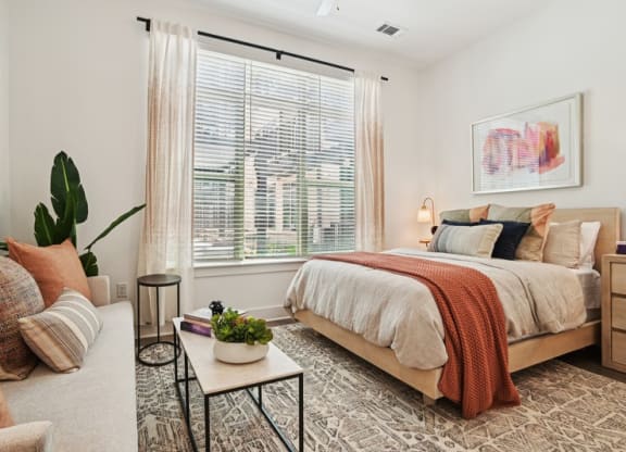 a bedroom with a bed and a large window
