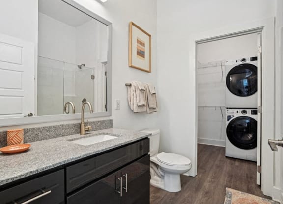 a bathroom with a sink and a toilet and a washing machine
