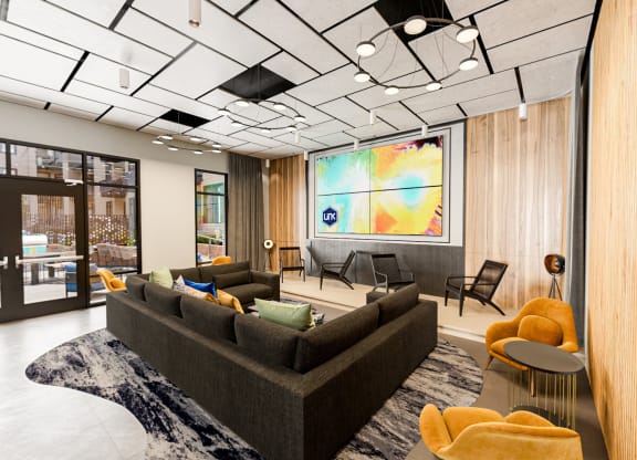 a lobby with couches and chairs and a projection screen