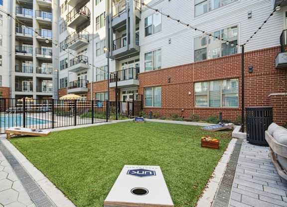 an apartment yard with a pool and an apartment building at Link Apartments® Calyx, Chapel Hill, NC 27517