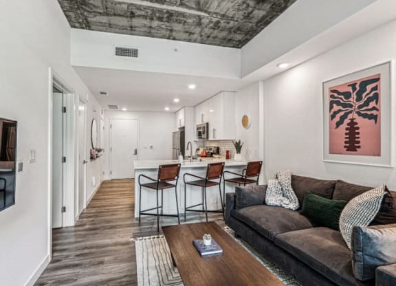 the living room is open to the kitchen and dining area at Link Apartments® Four 12, Oakland, 94607