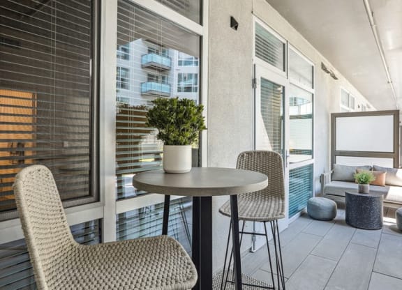 a balcony with two chairs and a table with a potted plant at Link Apartments® Four 12, Oakland
