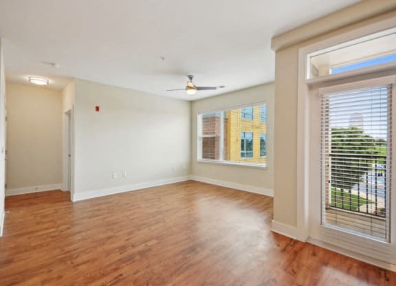 an empty living room with a large window and wood flooring at Link Apartments® Brookstown, Winston Salem, NC, 27101