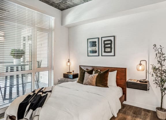 a bedroom with a bed and a large window at Link Apartments® Four 12, Oakland, CA