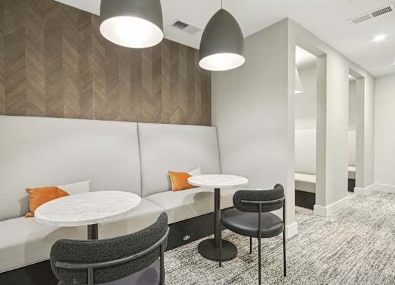 a seating area with two tables and two chairs in a room at Link Apartments® Calyx, Chapel Hill