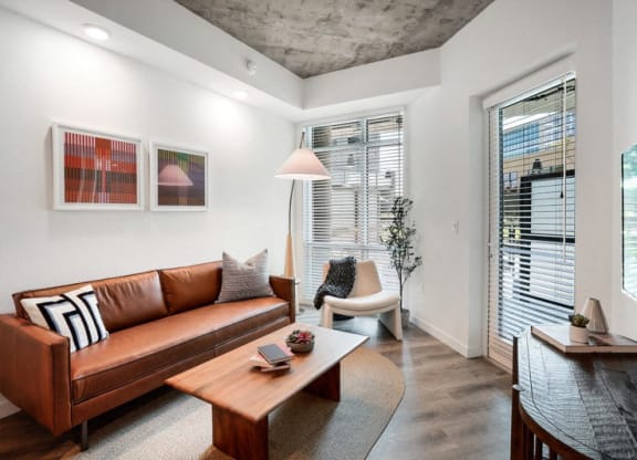 a living room with a leather couch and a coffee table at Link Apartments® Four 12, California, 94607