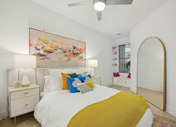 a bedroom with a white bed and a yellow blanket at Link Apartments® Calyx, Chapel Hill, 27517