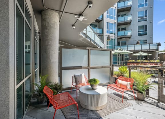a patio with red chairs and a table on a balcony at Link Apartments® Four 12, California