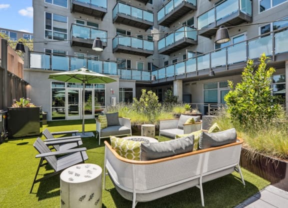an outdoor patio with furniture and a table and chairs at Link Apartments® Four 12, California