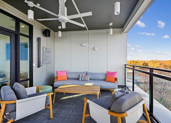 a living room with couches and chairs on a balcony at Link Apartments® Calyx, Chapel Hill North Carolina