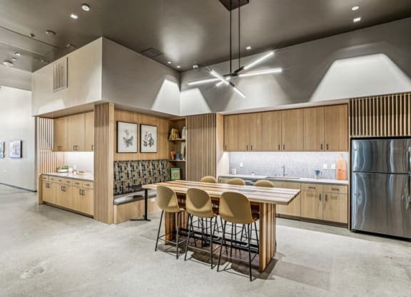 a kitchen with a wooden table and chairs and a stainless steel refrigerator at Link Apartments® Four 12, Oakland, CA, 94607