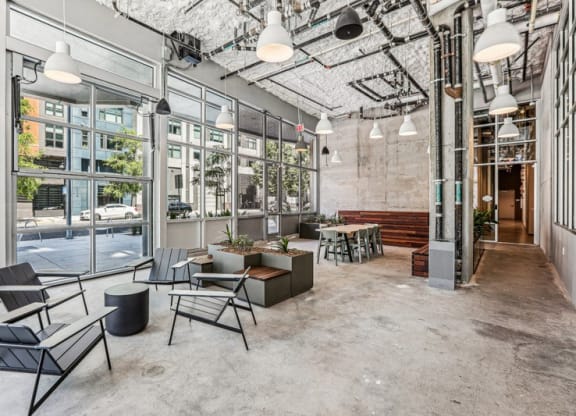 the lobby of a building with chairs and tables and large windows at Link Apartments® Four 12, California