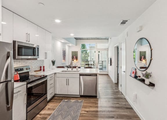 a large kitchen with white cabinets and stainless steel appliances at Link Apartments® Four 12, Oakland, CA