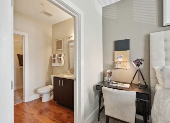 a bedroom with a desk and a bathroom with a toilet at Link Apartments® Brookstown, Winston Salem, NC, 27101