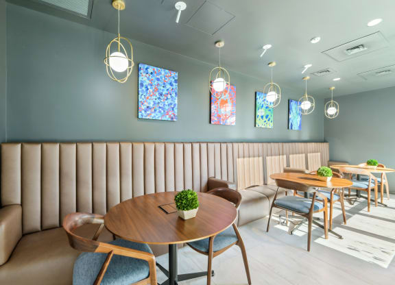 a dining room with tables and chairs and blue walls at Link Apartments® H Street, Washington