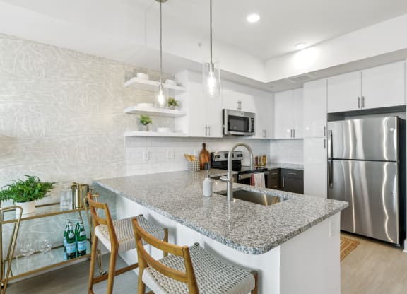 a kitchen with stainless steel appliances and granite counter tops  at Link Apartments® H Street, Washington, DC, 20002