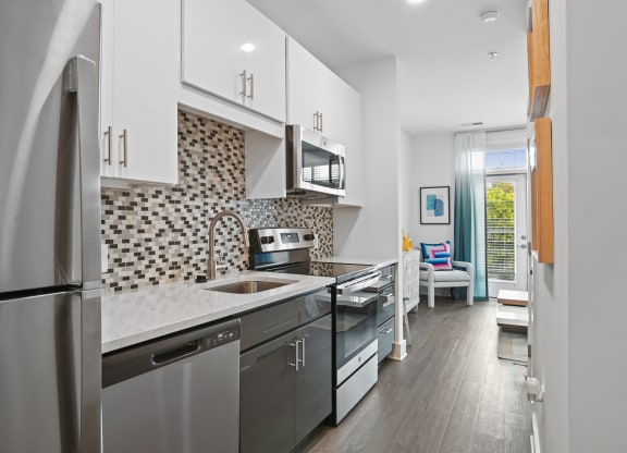 Studio kitchen with stainless steel appliances and quartz counters at Link Apartments® Mint Street in Uptown Charlotte, NC. at Link Apartments® Mint Street, Charlotte, NC, 28203