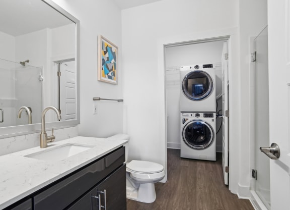 a bathroom with a toilet sink and a washing machine    and a laundry at Link Apartments® Mint Street, Charlotte, North Carolina