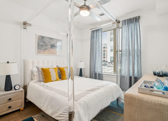 a bedroom with a white bed and a large window at Link Apartments® Mint Street, North Carolina, 28203