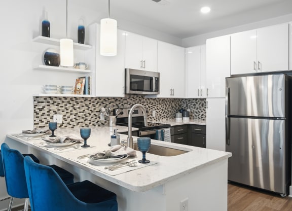 a kitchen with a island and a stainless steel refrigerator at Link Apartments® Mint Street, Charlotte, NC, 28203