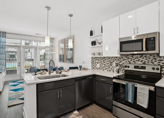 a kitchen with black and white appliances and a sink at Link Apartments® Mint Street, Charlotte, North Carolina