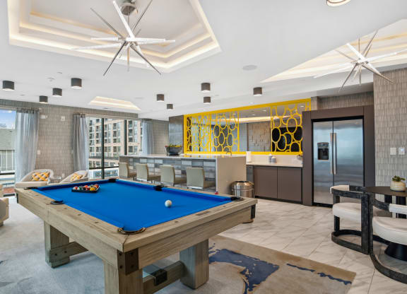 a pool table in a living room with a bar and a kitchen at Link Apartments® Mint Street, Charlotte, NC, 28203