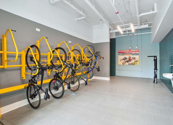 a room with several bikes hanging on a wall and a bathroom with sinks at Link Apartments® Mint Street, North Carolina, 28203