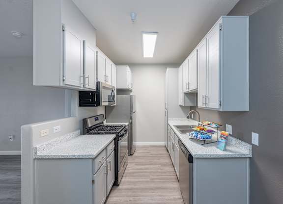 A kitchen with white cabinets and a grey countertop. at Cheyenne Villas, North Las Vegas, Nevada