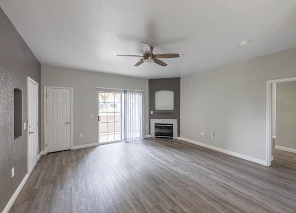 A spacious room with a ceiling fan and wooden flooring. at Cheyenne Villas, North Las Vegas, NV