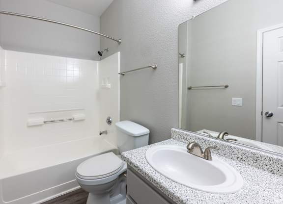 A white bathroom with a toilet, sink, and shower. at Cheyenne Villas, North Las Vegas, NV