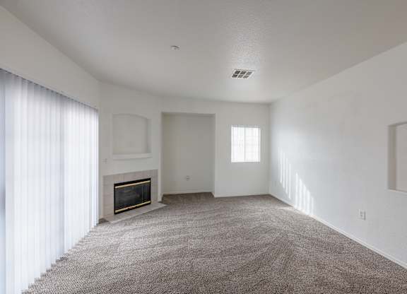 A living room with a fireplace and carpeted floor. at Cheyenne Villas, North Las Vegas