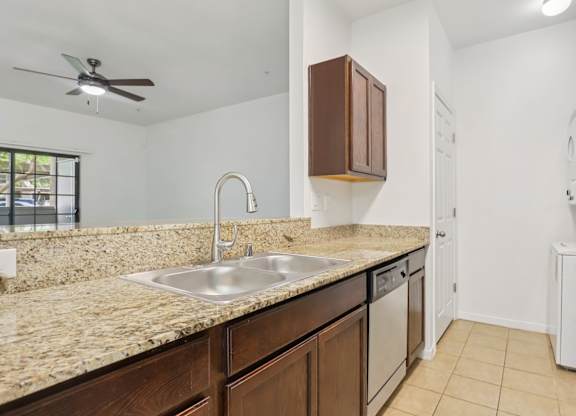 A kitchen with a sink, refrigerator, and cabinets. at Rome Park Villas, North Las Vegas, NV