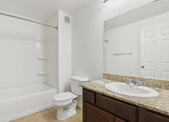 A white toilet sits in a bathroom next to a sink. at Rome Park Villas, North Las Vegas, 89084