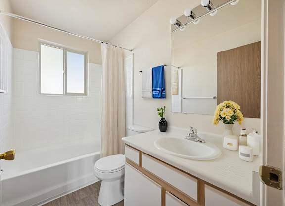A white bathroom with a toilet, sink, and bathtub.