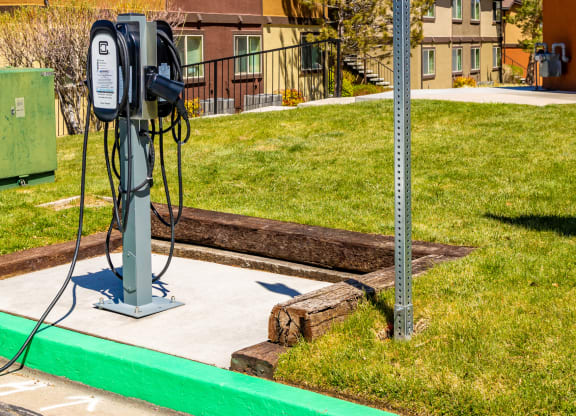a gas pump sitting next to a street sign in front of some houses