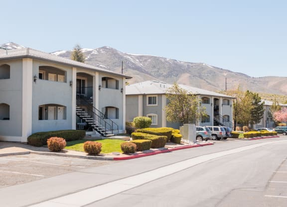 a row of apartment buildings with mountains in the background