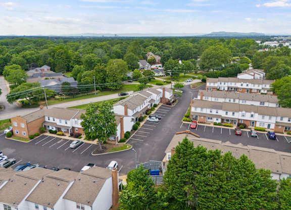 A bird's eye view of a residential area with houses and parked cars.