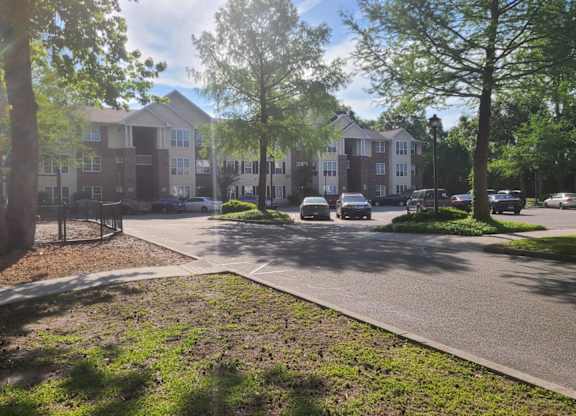 an apartment building with cars parked in a parking lot