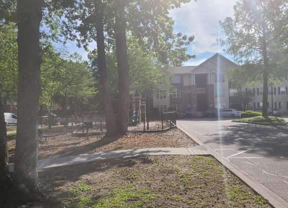 a city street with trees and a building