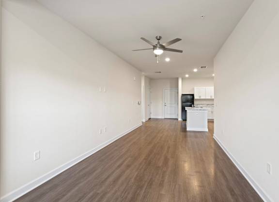 Peaks of Lexington Apartments Kitchen with Black Appliances, Granite Countertops and White Cabinetry and connected living room