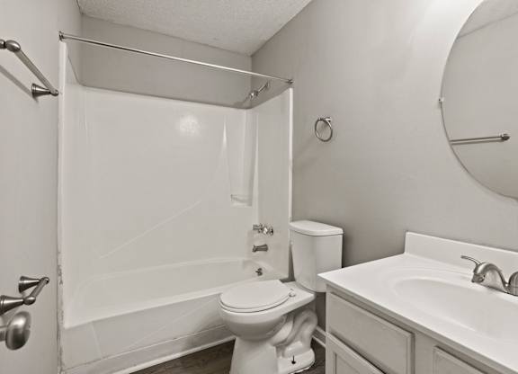 A white bathroom with a toilet, sink, and shower.